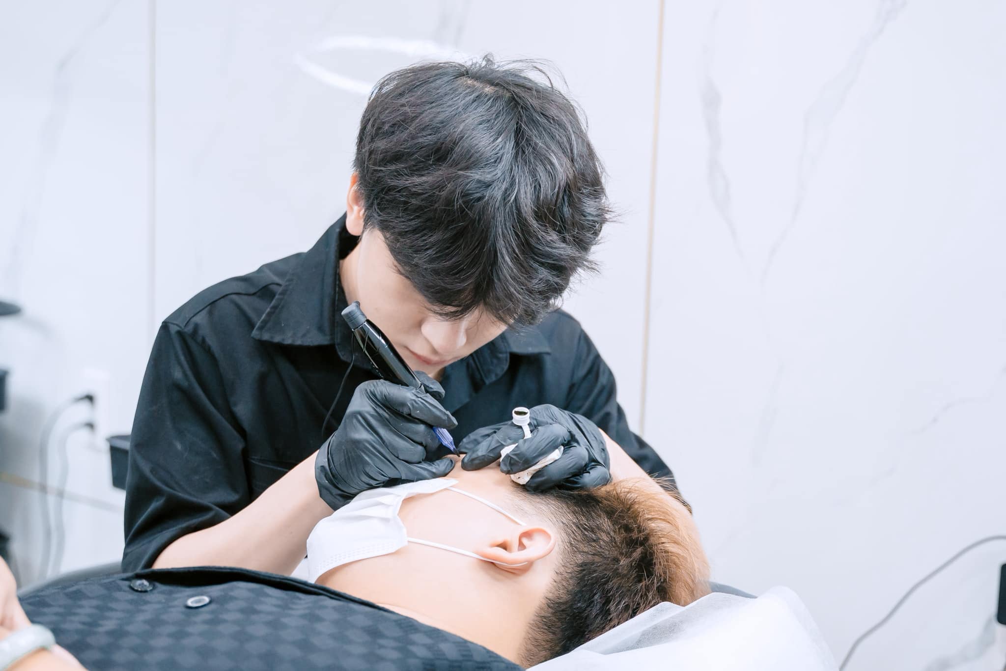 Chuyên gia Alpha Brows đi sợi chân mày cho khách nam